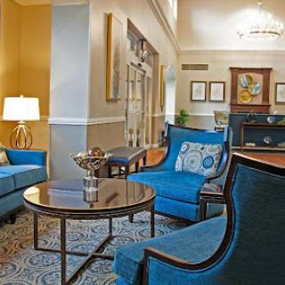 A stylish and inviting lobby seating area featuring blue chairs and a coffee table.