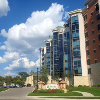 A modern residential building under a blue sky with fluffy clouds.