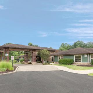 Entrance of a healthcare facility surrounded by green landscape.