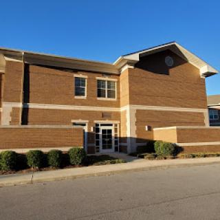 A brick building with a modern architectural design, captured in bright daylight.