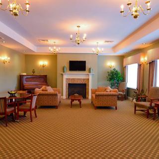 An elegant living room with a seating area, fireplace, and chandeliers.