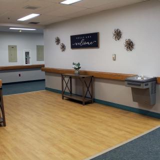 An empty dance studio with mirrors, barres, and decorative wall art.