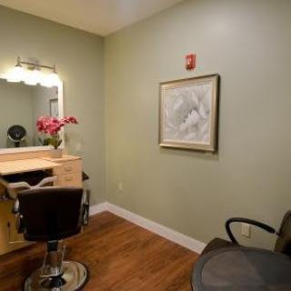 A cozy hair salon interior with a styling station and decorative elements.
