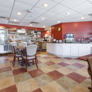 A cozy restaurant interior with a view of the dining area and kitchen.