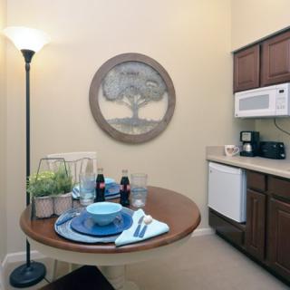 A cozy kitchen corner with a small dining table set for one, complete with dishware and utensils.