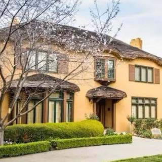 A charming two-story house with beautiful landscaping.