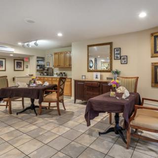 A cozy dining area with several tables and chairs, adorned with decorative mirrors and artwork on the walls.