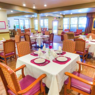 A well-lit restaurant dining area with neatly arranged tables and chairs.