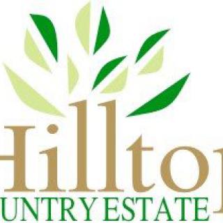 A logo for Hilton Country Estate featuring green leaves above the text.