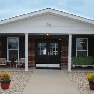 A welcoming front entrance of a residential building with a landscaped porch.