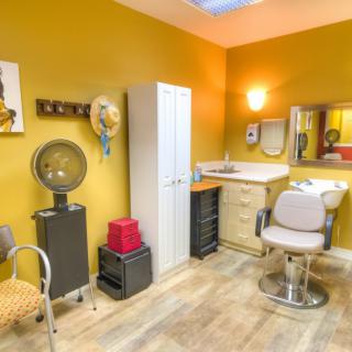 An inviting hair salon interior with a barber chair, sink, and wall decor.