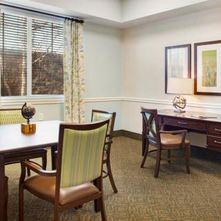 A well-lit office space featuring a desk, chairs, and decorative items.