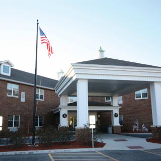 A brick building with an American flag and a grand entrance.