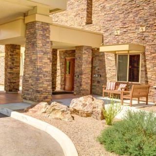 The entrance of a building with a stone facade and desert landscaping.