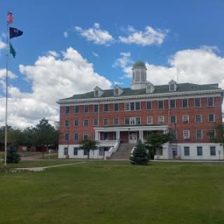 A historic building under a bright blue sky with scattered clouds.