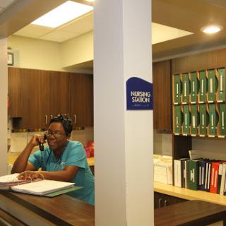 A receptionist at work, managing calls and paperwork in a well-organized office environment.