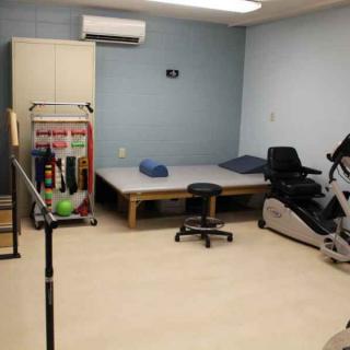 A physical therapy room equipped with various exercise and rehabilitation tools.