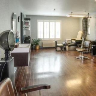 A spacious beauty salon interior with chairs and styling equipment.