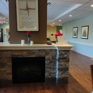 A cozy lobby area featuring a modern fireplace, decorative elements, and artwork on the walls.