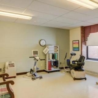 A small fitness room equipped with exercise machines for therapy and rehabilitation.