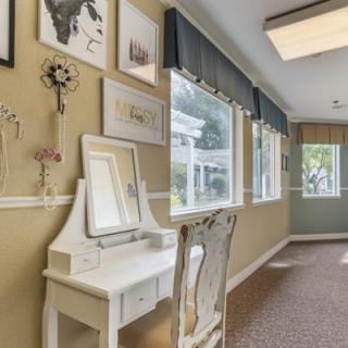 A bright hallway with a vanity table and artwork on the walls.