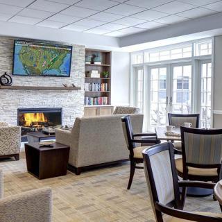 A cozy living room featuring a fireplace, comfortable seating, and a television mounted above.