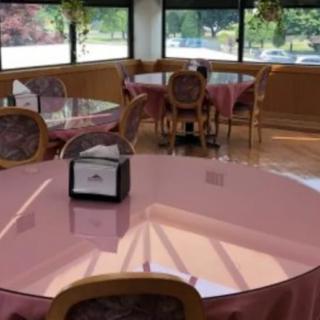An indoor dining area with tables and chairs, featuring a napkin holder on one of the tables.