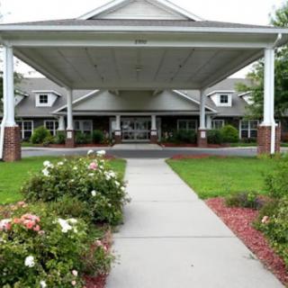 A well-maintained building entrance with a covered walkway and landscaped garden.