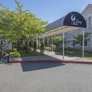 A building entrance with an awning and a landscaped driveway.