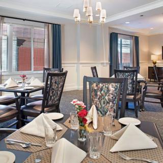 An elegantly set dining room with neatly arranged tables and chairs, ready for guests.