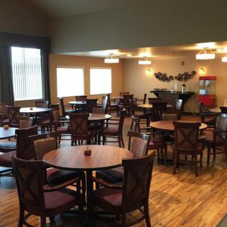 An empty dining room with neatly arranged tables and chairs.