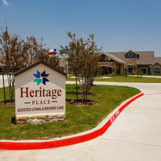 A view of Heritage Place, an assisted living and memory care facility with a clear, sunny sky.