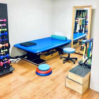 A well-equipped physiotherapy room featuring various exercise tools and a treatment table.