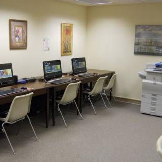 An empty office with several computer workstations and a printer.
