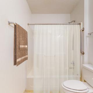 A clean and modern bathroom featuring a shower curtain, towel, and toilet.