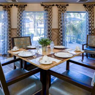 A well-decorated dining area with a neatly set table and elegant curtains.