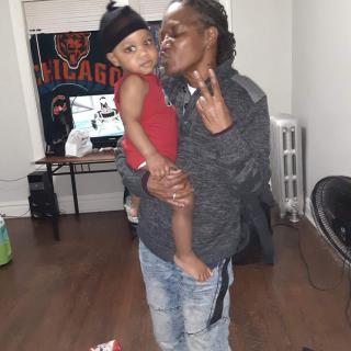 A person holding a child indoors, showing affection.