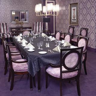 An elegantly decorated dining room with a long table set for a formal gathering.