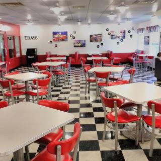 A retro-themed diner with red chairs and a checkered floor.