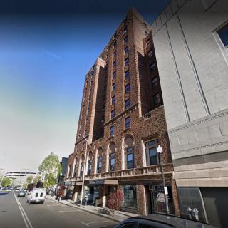 A view of a multi-story brick building on a city street.