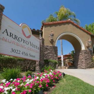 Entrance to Arroyo Vista with a landscaped sign and stone archway.