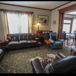 A cozy living room with leather couches, an armchair, and various decor.
