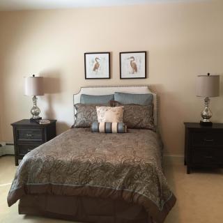 A cozy bedroom with decorative elements and a neatly made bed.