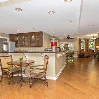 A modern open-concept kitchen and dining area with wood flooring and cozy seating.