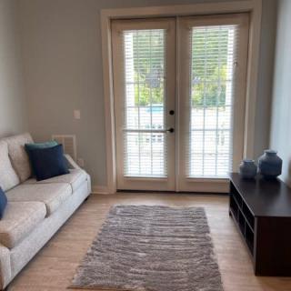 A cozy living room with a sofa, decorative pillows, and French doors allowing natural light to brighten the space.
