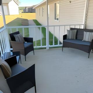 A cozy patio setup with chairs and a loveseat, adorned with cushions.