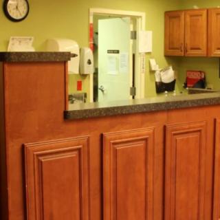 A reception area with a wooden desk in an office setting.