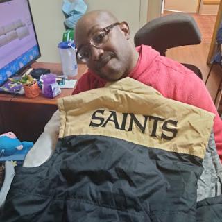 A person enjoying a casual moment with a SAINTS jacket.