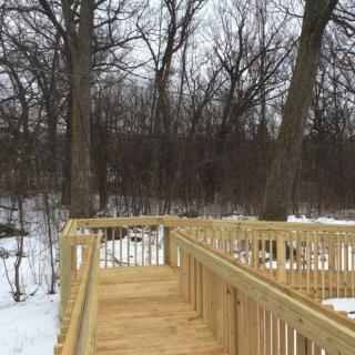 A wooden walkway in a snowy forest landscape.