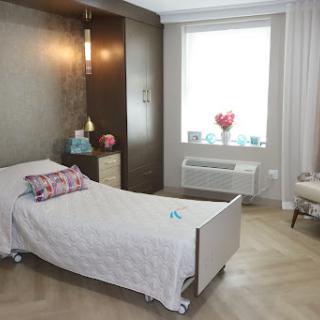 A beautifully designed modern bedroom featuring a white bed, decorative pillows, and ample natural light.